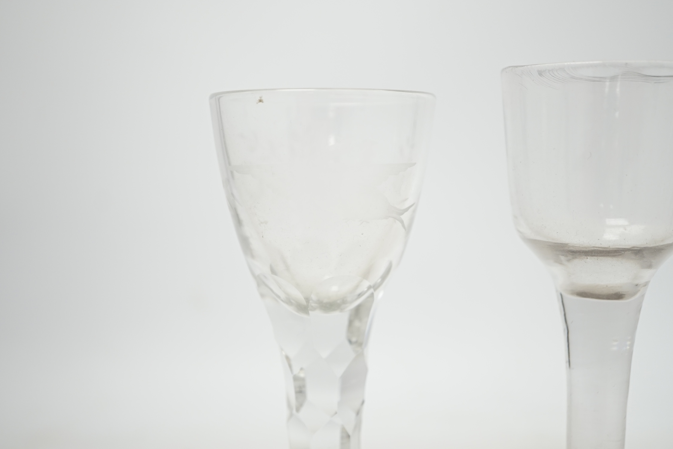 Three 18th century wine glasses; a drawn trumpet glass, another with a bell shaped bowl and folded foot and an engraved glass with a faceted stem, tallest 16.5cm. Condition - good